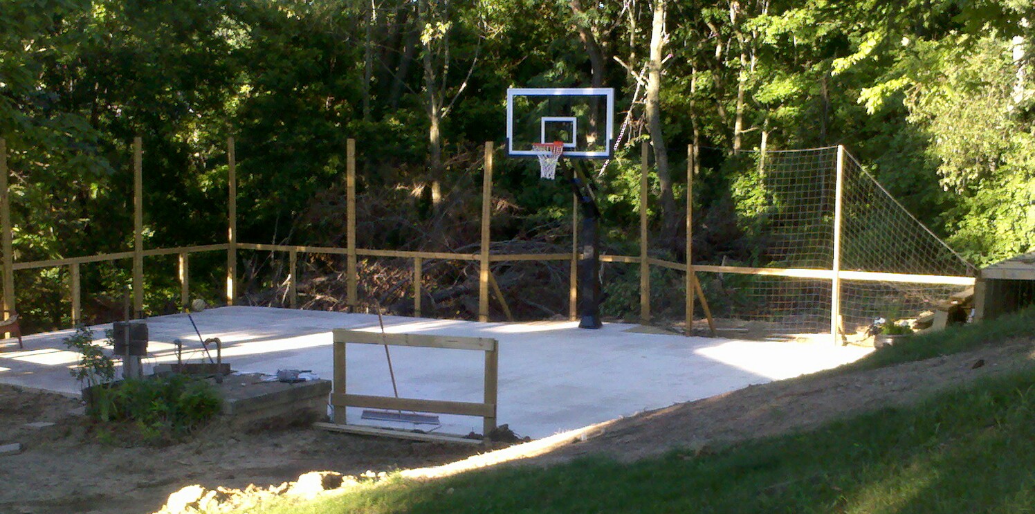 There is the net fence behind the court and the hoop.
